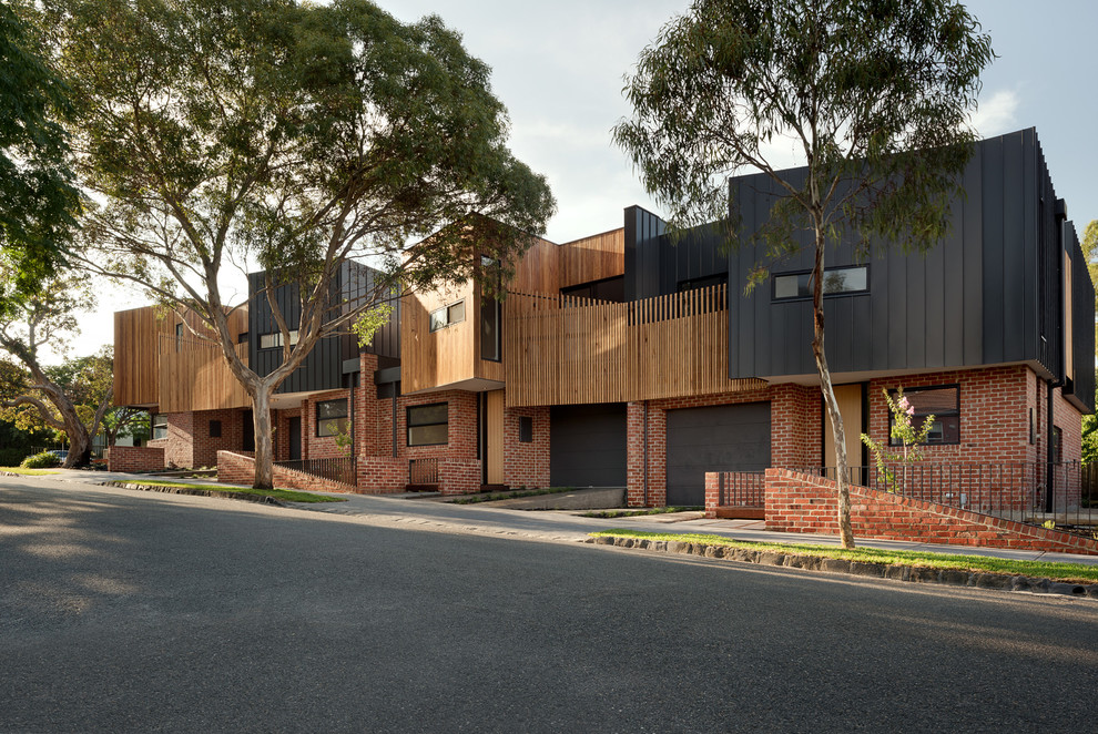 Inspiration for a mid-sized contemporary two-storey black exterior in Melbourne with metal siding and a flat roof.