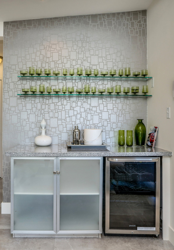 Photo of a small retro single-wall home bar in San Diego with glass-front cabinets, white cabinets, granite worktops, grey splashback, porcelain flooring, grey floors and grey worktops.