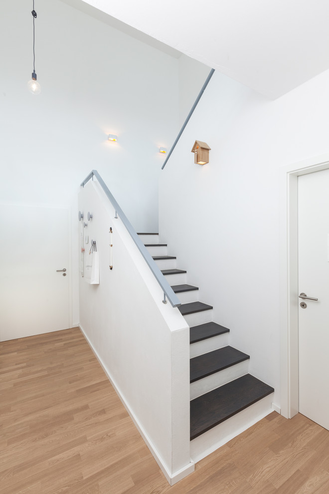 This is an example of a mid-sized contemporary wood u-shaped staircase in Bremen with concrete risers.