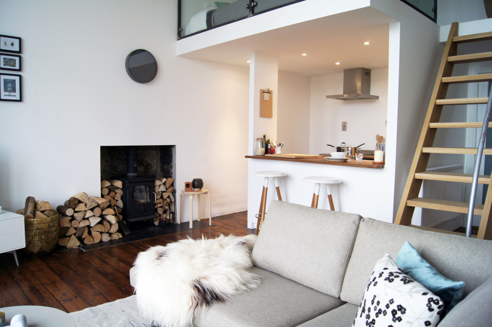 This is an example of a mid-sized scandinavian open concept living room in Glasgow with white walls, dark hardwood floors, a freestanding tv and brown floor.