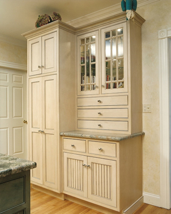 Inspiration for a large traditional single-wall kitchen pantry in Boston with glass-front cabinets, beige cabinets, granite benchtops, beige splashback, stainless steel appliances, light hardwood floors and with island.