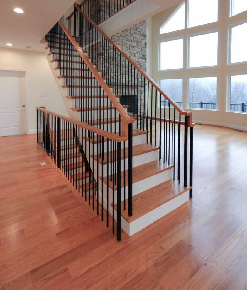 Inspiration for a large transitional wood floating staircase in DC Metro with wood risers, mixed railing and planked wall panelling.