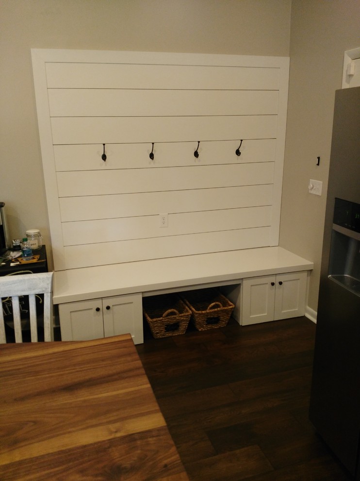 Example of a mid-sized transitional l-shaped dark wood floor and brown floor eat-in kitchen design with a farmhouse sink, shaker cabinets, white cabinets, wood countertops, stainless steel appliances, an island, gray backsplash and marble backsplash