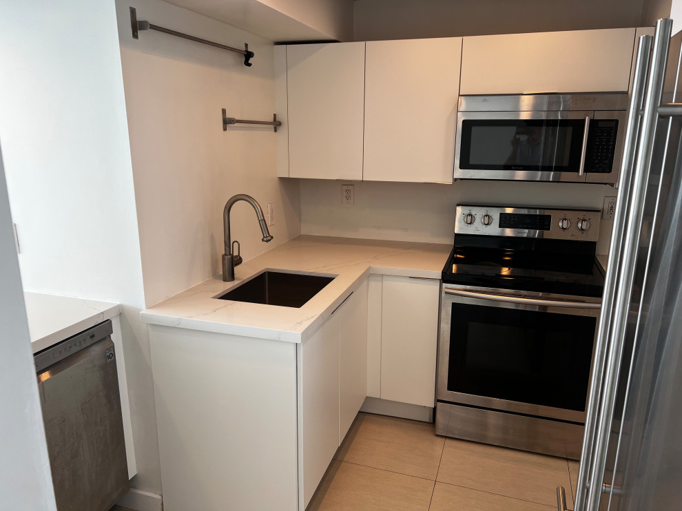 Immagine di una piccola cucina a L minimalista chiusa con ante bianche e top in quarzo composito