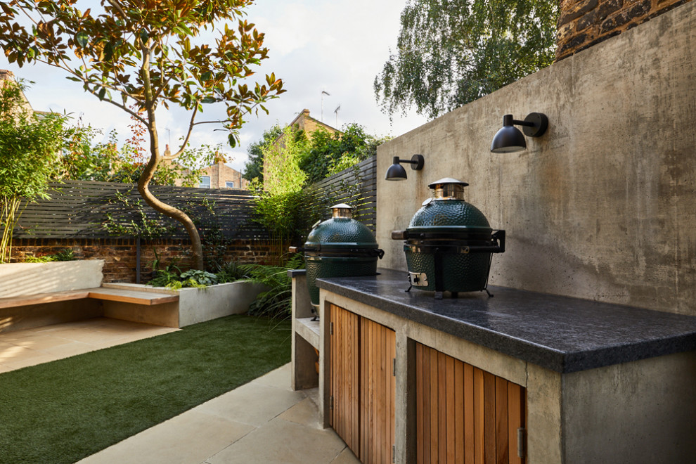 Photo of a small contemporary back partial sun garden in London with a wood fence.