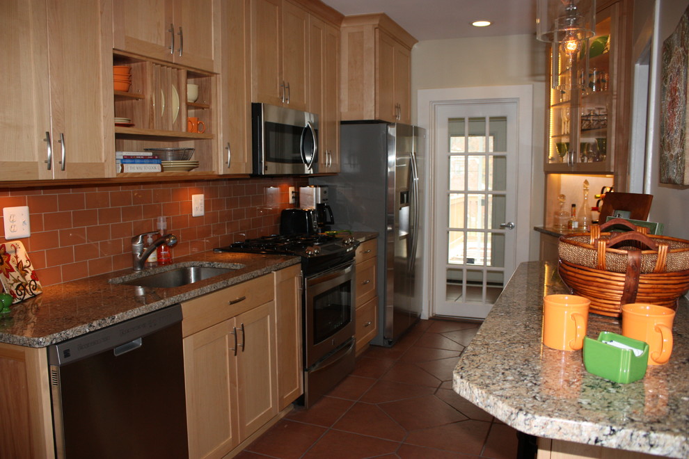 Enclosed kitchen - small transitional galley porcelain tile enclosed kitchen idea in Baltimore with an undermount sink, shaker cabinets, light wood cabinets, granite countertops, orange backsplash, glass tile backsplash, stainless steel appliances and no island