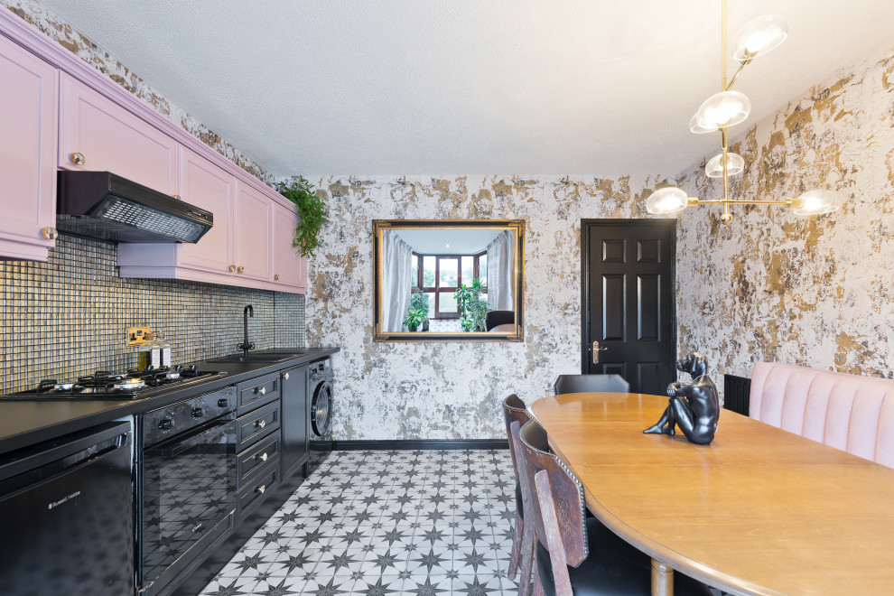 This is an example of a large eclectic single-wall eat-in kitchen in Dublin with a drop-in sink, recessed-panel cabinets, black cabinets, multi-coloured splashback, black appliances, ceramic floors, no island, multi-coloured floor and black benchtop.