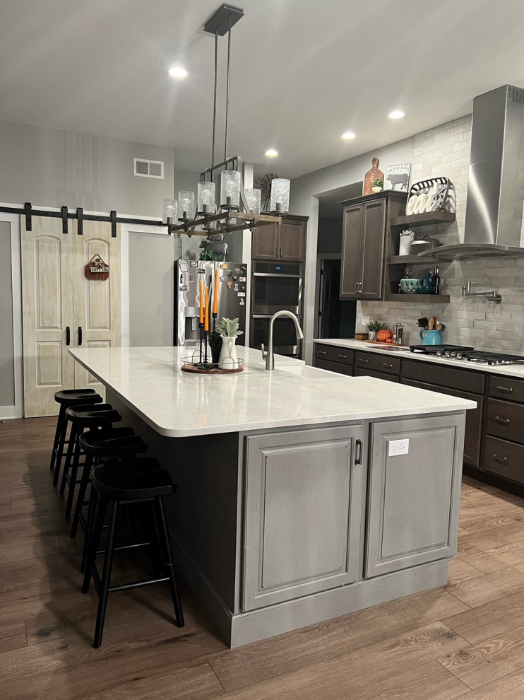 Design ideas for a large transitional kitchen in Philadelphia with a farmhouse sink, recessed-panel cabinets, dark wood cabinets, quartz benchtops, stainless steel appliances, with island and white benchtop.