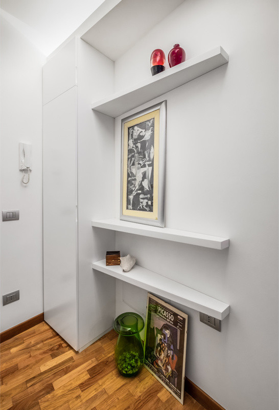 This is an example of a small contemporary hallway in Rome with white walls, light hardwood floors and brown floor.