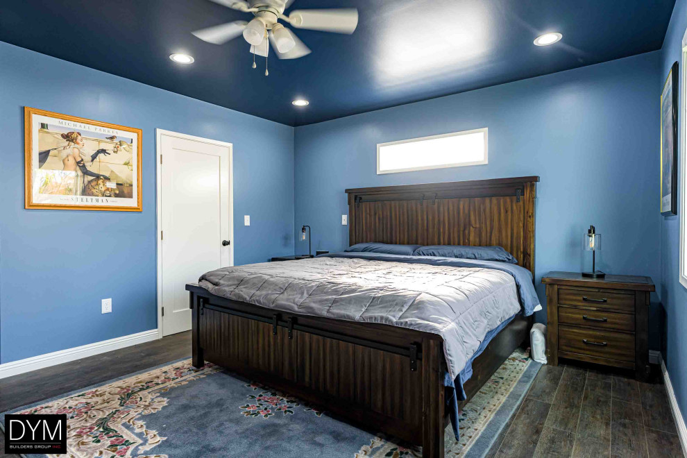 Idées déco pour une chambre parentale contemporaine de taille moyenne avec un mur bleu, parquet foncé, un sol marron, un plafond en papier peint et du papier peint.