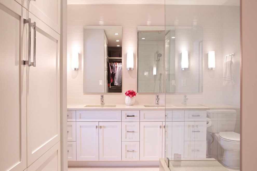 Photo of a large contemporary master bathroom in Calgary with shaker cabinets, white cabinets, a corner shower, beige tile, porcelain tile, grey walls, porcelain floors, an undermount sink and engineered quartz benchtops.