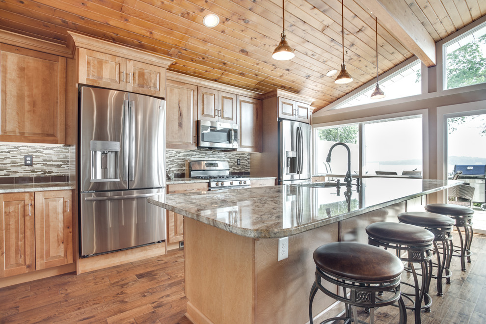 Inspiration for a large rustic kitchen remodel in DC Metro with an undermount sink, raised-panel cabinets, granite countertops, glass tile backsplash, stainless steel appliances and an island