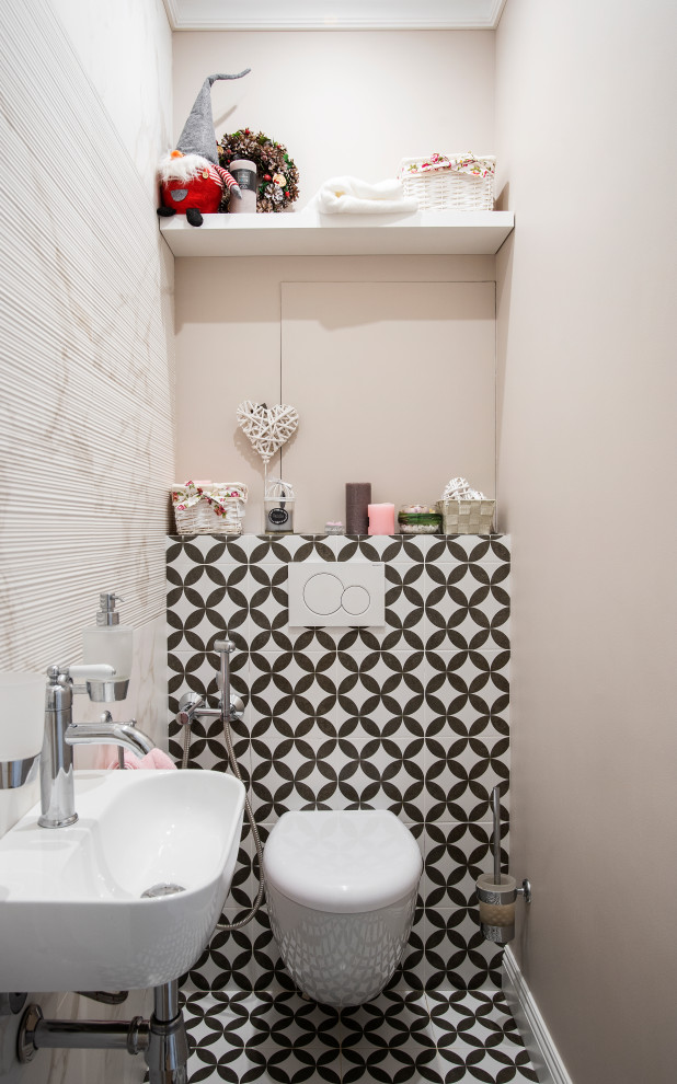 Inspiration for a mid-sized contemporary powder room in Moscow with a wall-mount toilet, black and white tile, beige walls, a wall-mount sink and multi-coloured floor.