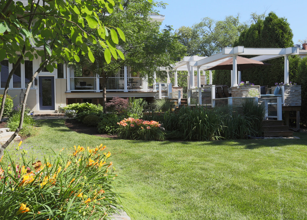 Huge transitional backyard outdoor kitchen deck photo in Chicago with a pergola