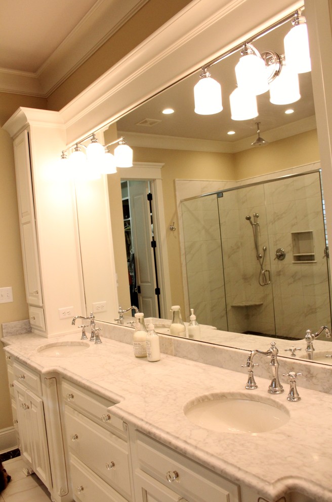 Inspiration for a master bathroom in Miami with an undermount sink, raised-panel cabinets, white cabinets, marble benchtops, a freestanding tub, a double shower, a one-piece toilet, white tile, beige walls and ceramic floors.