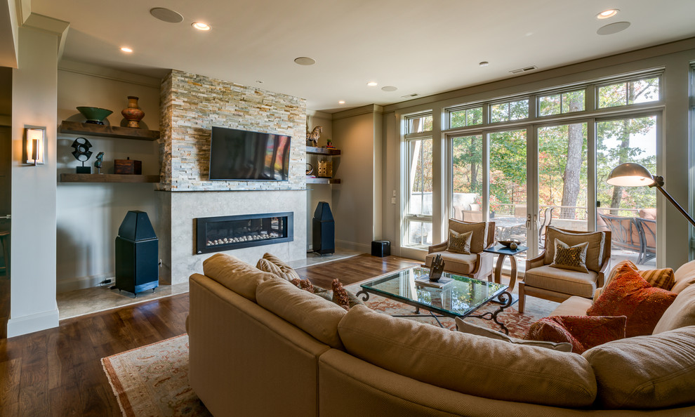 Large transitional enclosed family room in Other with a home bar, grey walls, dark hardwood floors, a ribbon fireplace, a stone fireplace surround and a wall-mounted tv.