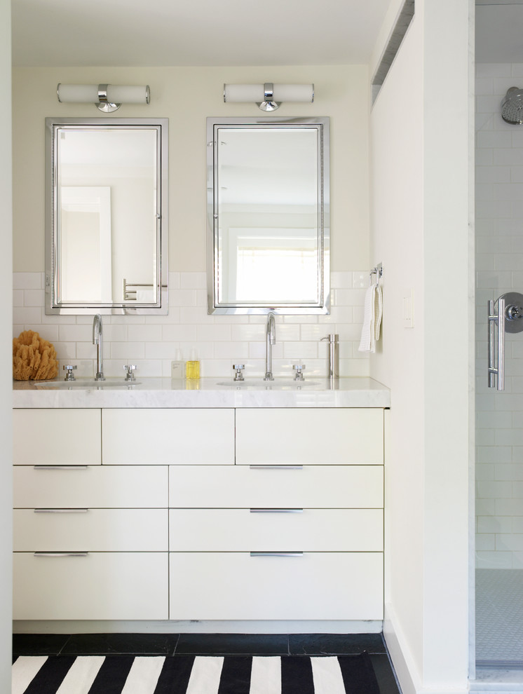 This is an example of a contemporary bathroom in Boston with marble benchtops, subway tile, flat-panel cabinets and white cabinets.