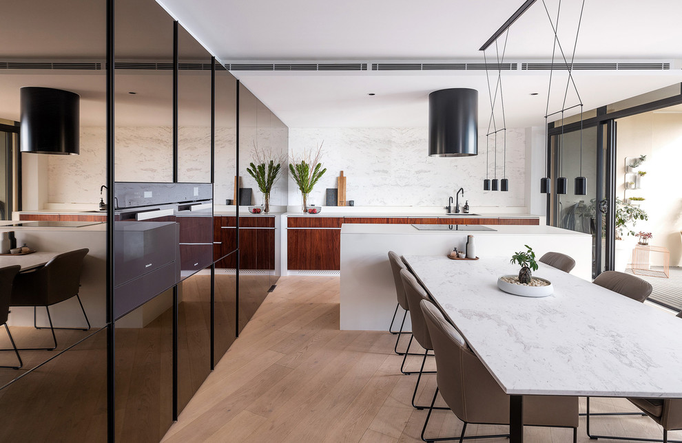 Inspiration for a small contemporary galley eat-in kitchen in Sydney with an undermount sink, flat-panel cabinets, marble benchtops, white splashback, marble splashback, light hardwood floors, with island, white benchtop, dark wood cabinets and brown floor.