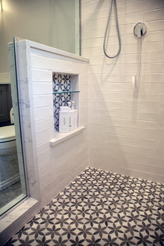Idéer för mellanstora maritima badrum med dusch, med en dusch i en alkov, vit kakel, marmorkakel och svart golv