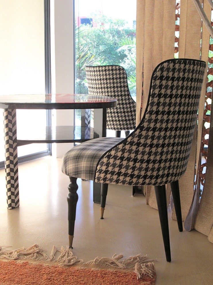 Un altro angolo con le grandi vetrate sul giardino mediterraneo, delimitato da una tenda in tessuto e rame, con poltroncine vintage e tavolino da salotto originale anni '40 rielaborato artisticamente