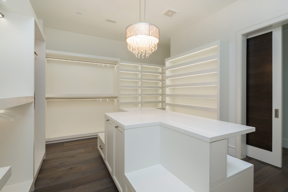Design ideas for a large traditional women's dressing room in Los Angeles with recessed-panel cabinets, white cabinets, medium hardwood floors and brown floor.