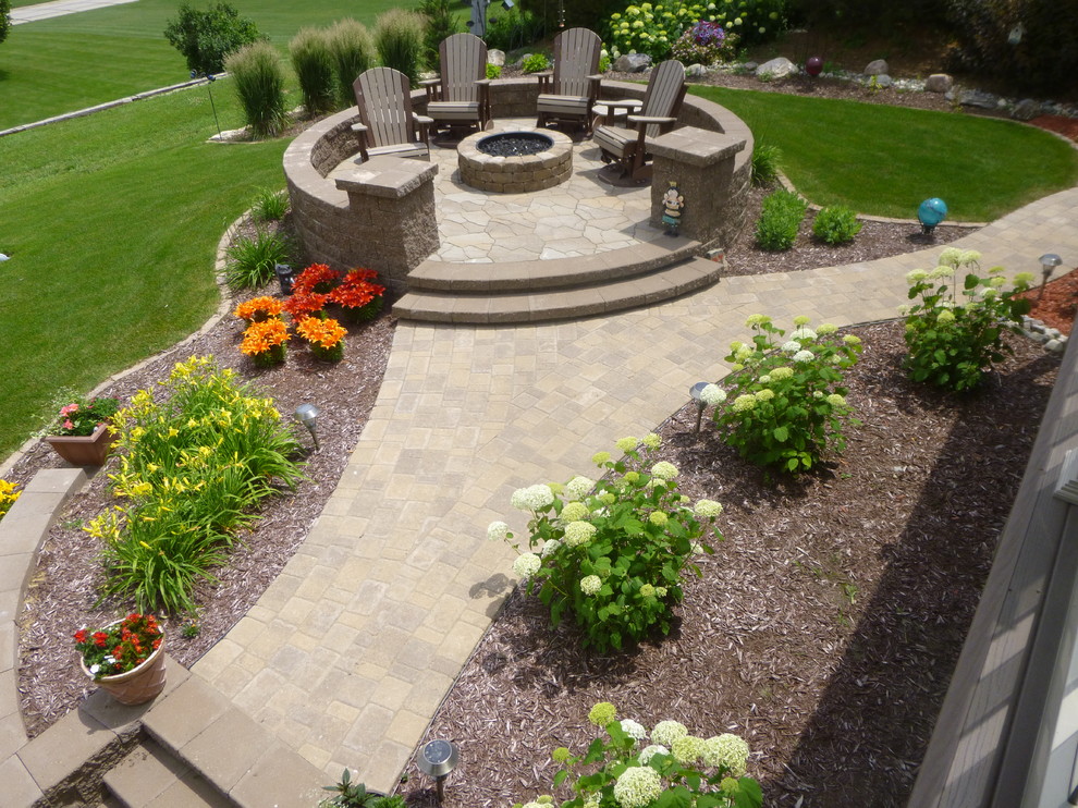 Photo of a large transitional backyard patio in Other with a fire feature, natural stone pavers and no cover.