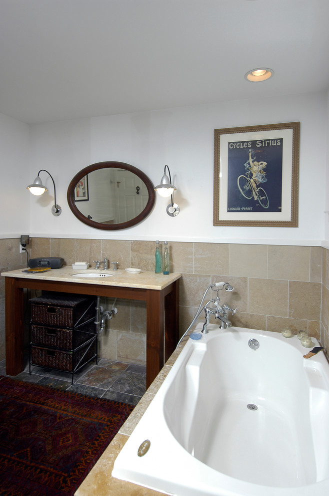 Photo of a mid-sized arts and crafts 3/4 bathroom in DC Metro with open cabinets, beige cabinets, an undermount tub, an alcove shower, a two-piece toilet, beige tile, ceramic tile, white walls, limestone floors, an undermount sink, granite benchtops, grey floor and a shower curtain.