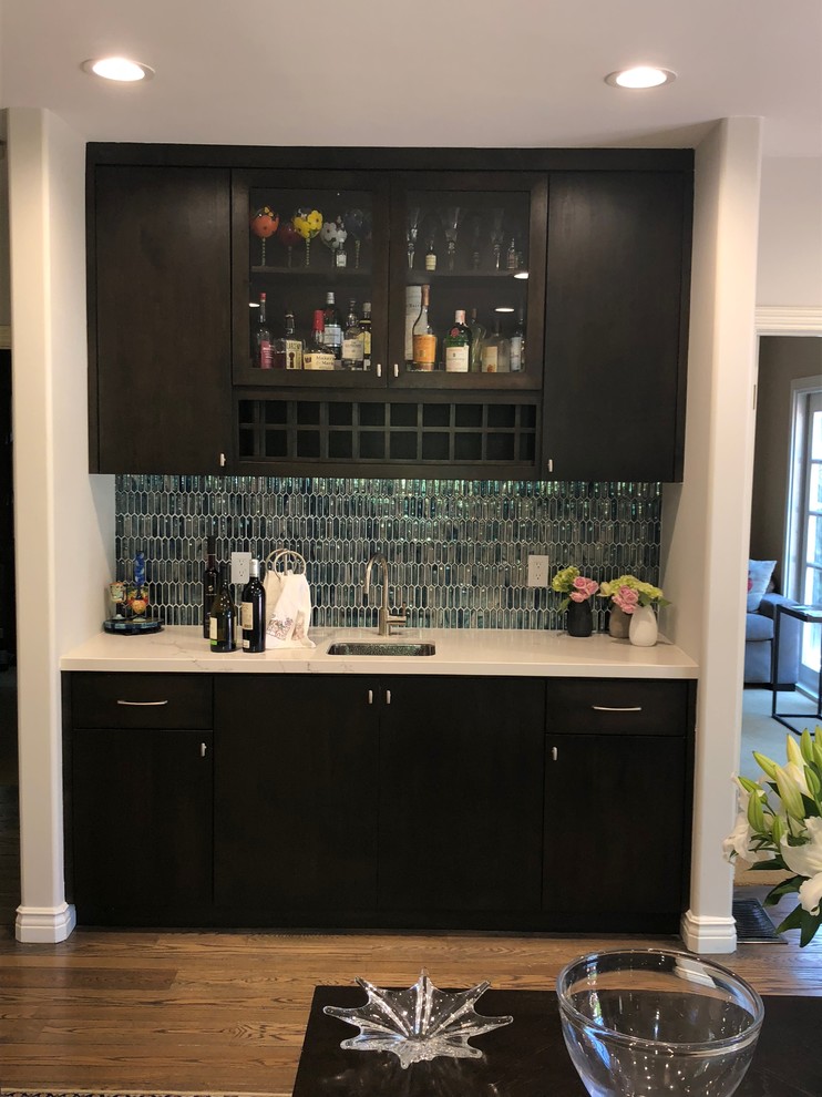 This is an example of a single-wall wet bar in Los Angeles with an undermount sink, flat-panel cabinets, dark wood cabinets, quartz benchtops and glass tile splashback.