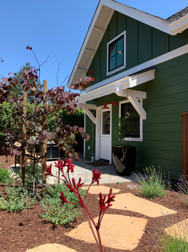 This is an example of a small arts and crafts two-storey green house exterior in San Francisco with wood siding, a gable roof, a shingle roof, a grey roof and clapboard siding.