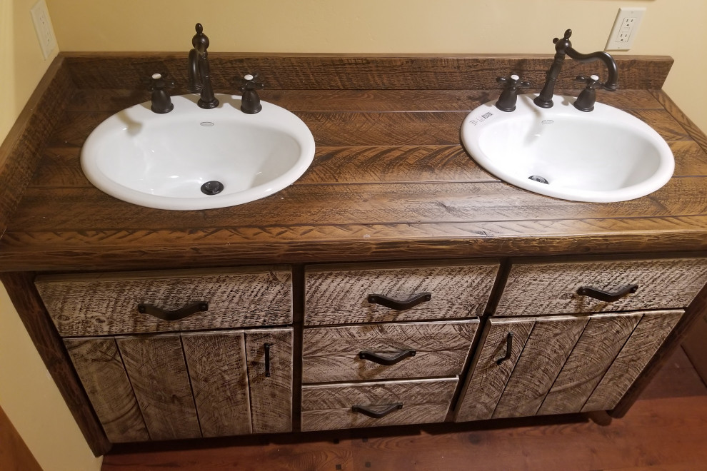 Inspiration for a mid-sized country master bathroom in Other with furniture-like cabinets, medium wood cabinets, a claw-foot tub, a shower/bathtub combo, a two-piece toilet, yellow walls, medium hardwood floors, a drop-in sink, wood benchtops, brown floor, a shower curtain, brown benchtops, a double vanity, a freestanding vanity and panelled walls.