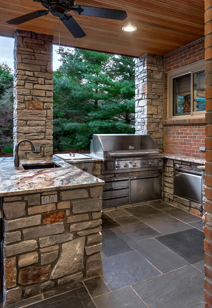 Photo of a mid-sized contemporary backyard patio in Detroit with an outdoor kitchen, natural stone pavers and a pergola.