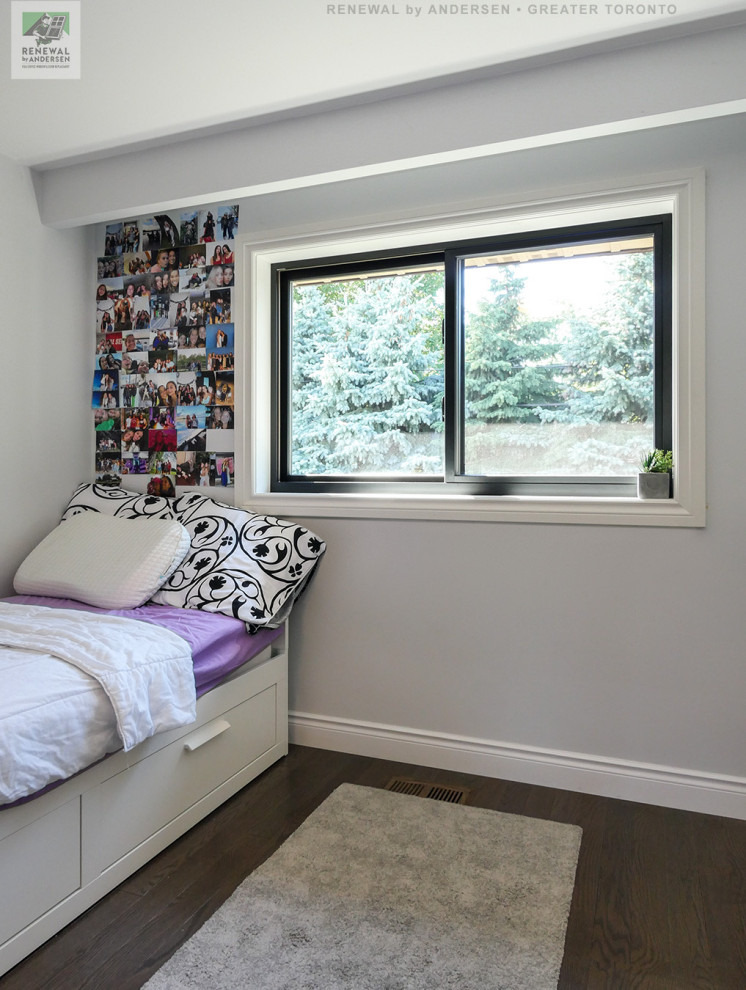 This is an example of a small gender-neutral kids' room in Toronto with grey walls, dark hardwood floors, multi-coloured floor and vaulted.