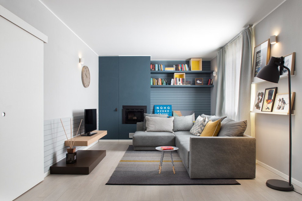 This is an example of a mid-sized contemporary enclosed family room in Milan with light hardwood floors and multi-coloured walls.