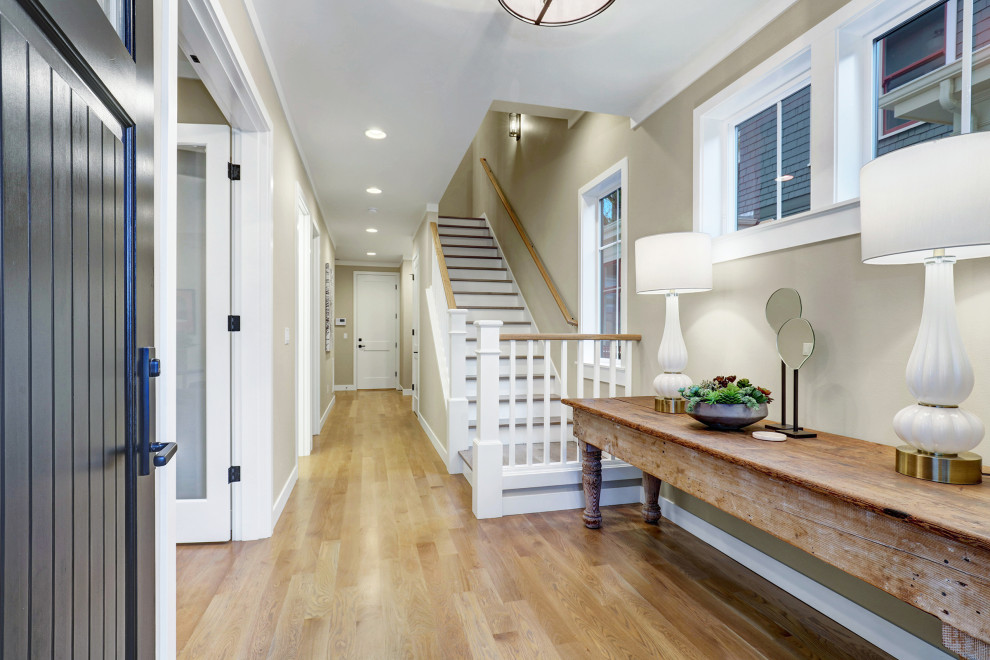 Foyer - contemporary light wood floor foyer idea in Seattle with a black front door