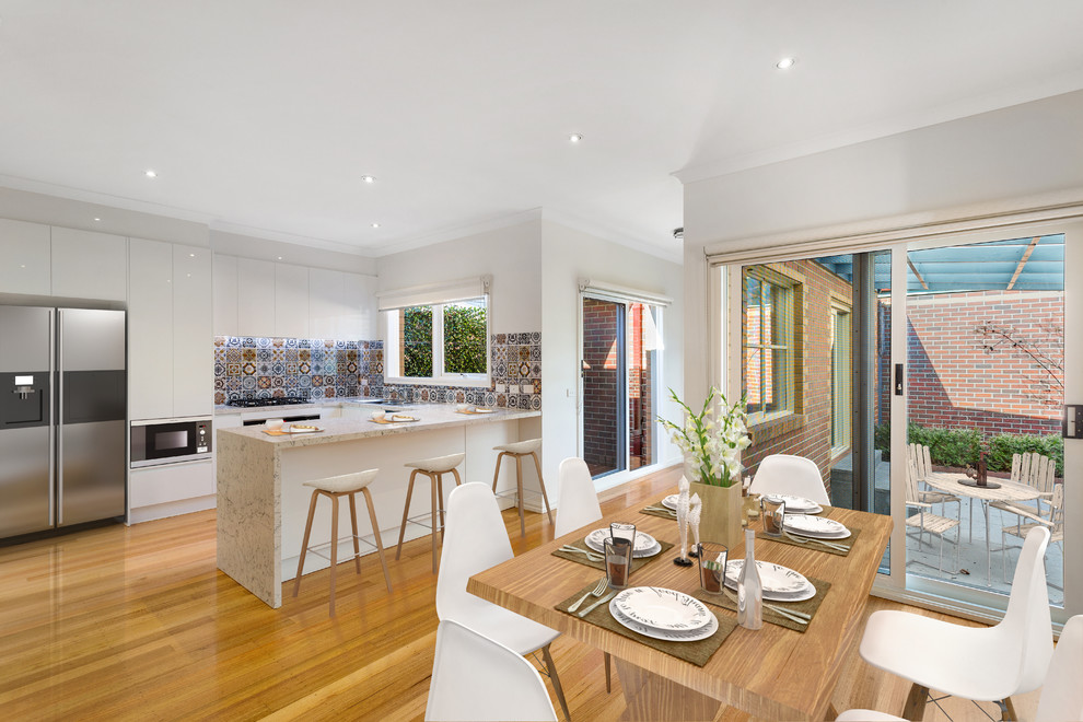 Design ideas for a mid-sized contemporary kitchen/dining combo in Melbourne with light hardwood floors and brown floor.