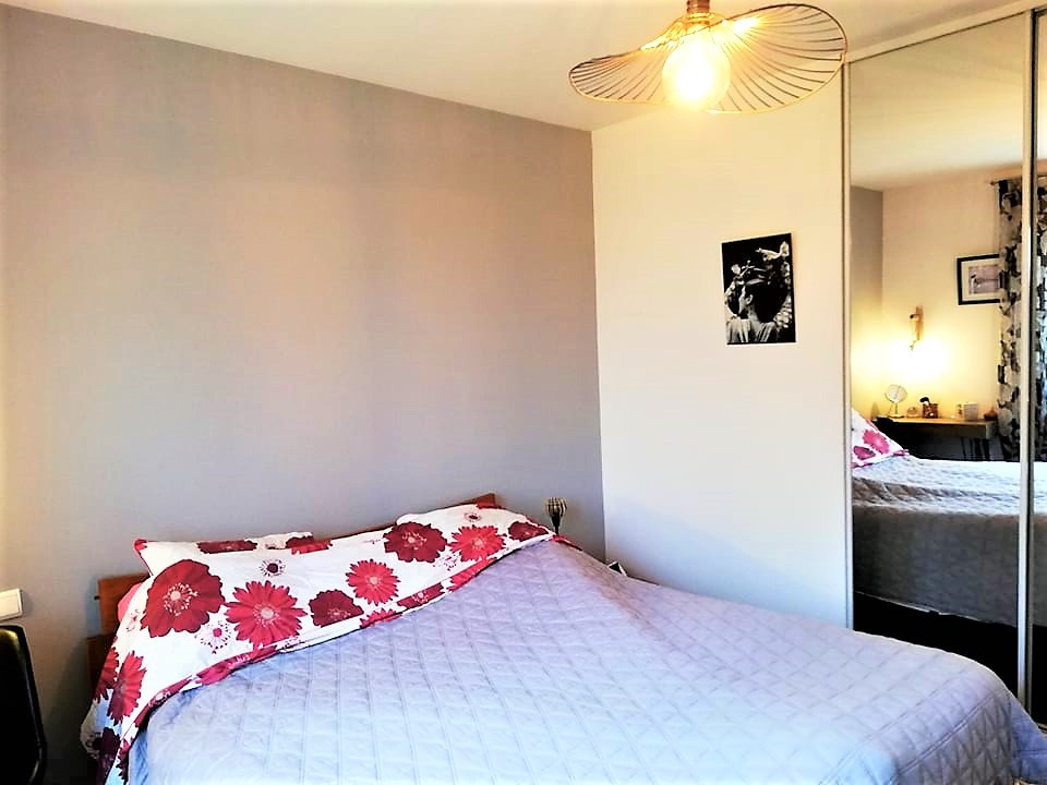 Imagen de dormitorio principal y gris y blanco bohemio de tamaño medio sin chimenea con paredes grises, suelo laminado y suelo gris