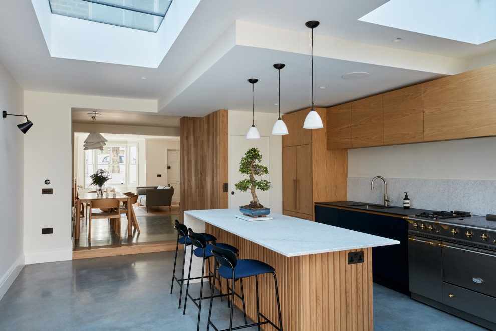 Design ideas for a medium sized contemporary single-wall kitchen/diner in London with a built-in sink, flat-panel cabinets, light wood cabinets, composite countertops, grey splashback, marble splashback, integrated appliances, lino flooring, an island, grey floors and grey worktops.
