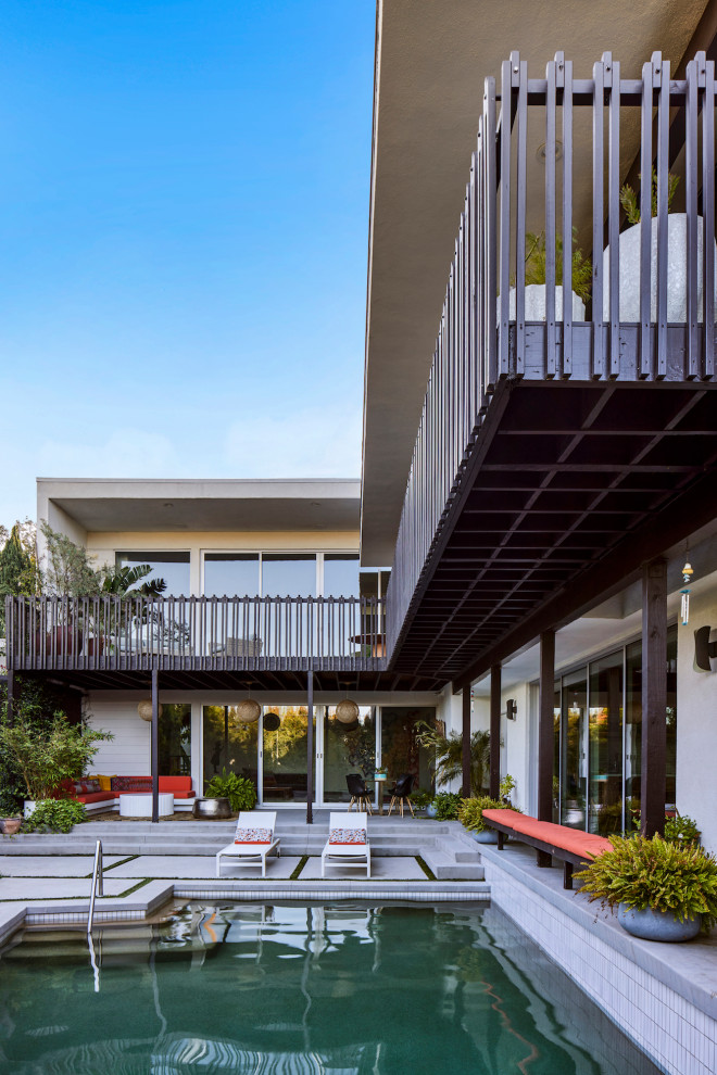 Immagine di un grande patio o portico minimalista dietro casa con lastre di cemento e una pergola