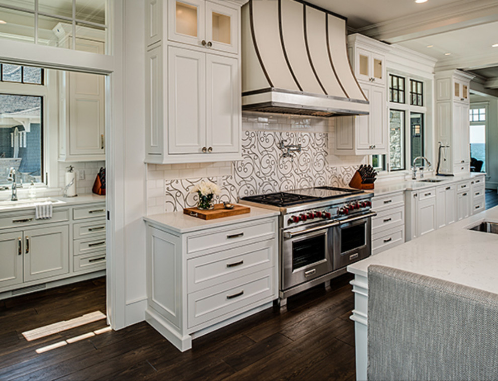 Example of a large transitional galley dark wood floor and brown floor open concept kitchen design with a double-bowl sink, recessed-panel cabinets, white cabinets, white backsplash, stainless steel appliances and two islands