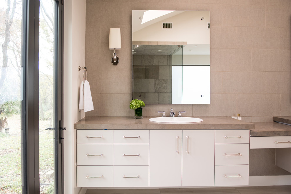 Drop-in bathtub - mid-sized transitional master gray tile and cement tile light wood floor and beige floor drop-in bathtub idea in Dallas with flat-panel cabinets, gray cabinets, gray walls, a drop-in sink, concrete countertops and a hinged shower door