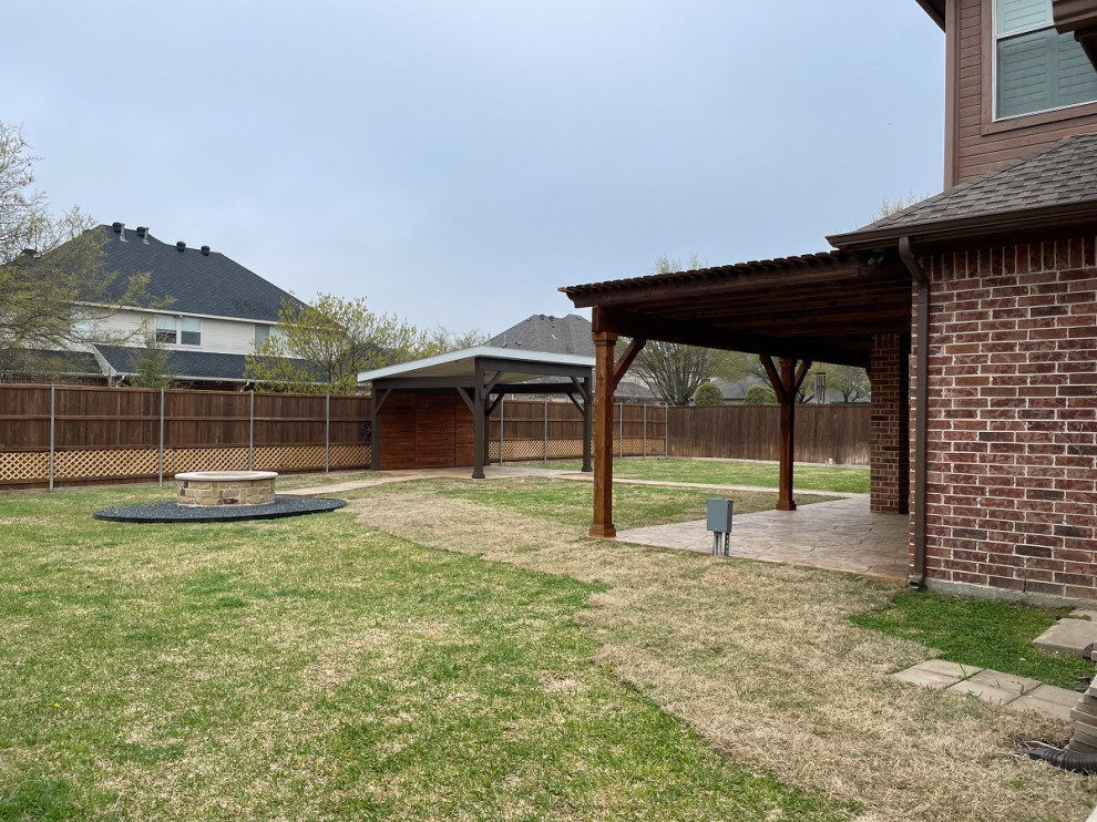 Expansive rustic back patio in Dallas with a fire feature, stamped concrete and a gazebo.