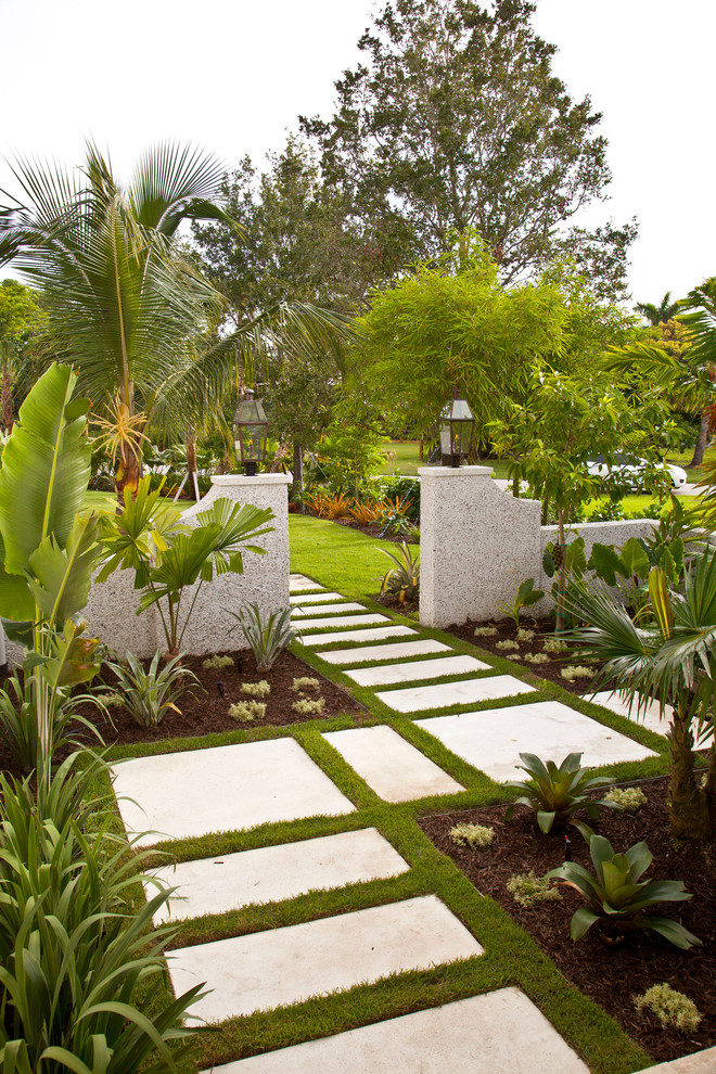 Photo of a mid-sized tropical front yard full sun garden in Tampa with a garden path and concrete pavers.
