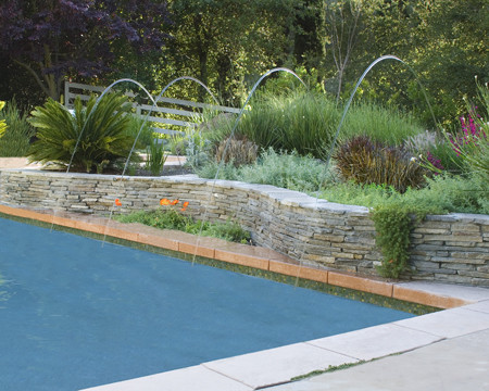Inspiration for a large country backyard rectangular lap pool in San Francisco with natural stone pavers and a water feature.