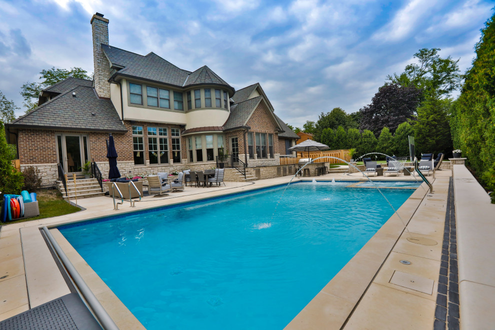 Esempio di una piscina monocorsia chic rettangolare di medie dimensioni e dietro casa con pavimentazioni in pietra naturale