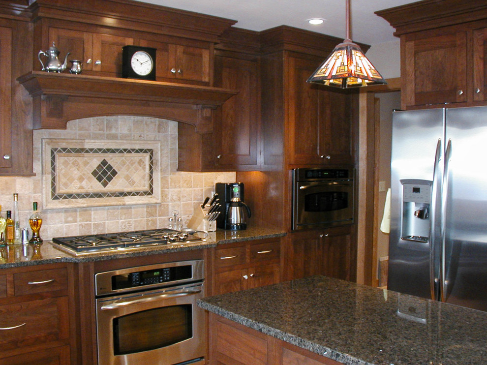 Inspiration for a mid-sized l-shaped eat-in kitchen remodel with an undermount sink, shaker cabinets, dark wood cabinets, granite countertops, stainless steel appliances and an island