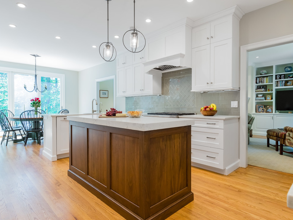 Eat-in kitchen - transitional u-shaped eat-in kitchen idea in Providence with an undermount sink, white cabinets, quartzite countertops, glass tile backsplash, stainless steel appliances and an island