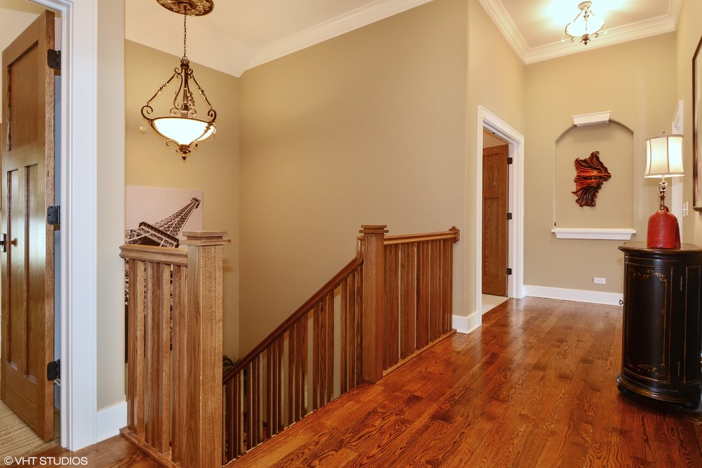 This is an example of a large arts and crafts wood u-shaped staircase in Chicago with wood risers.