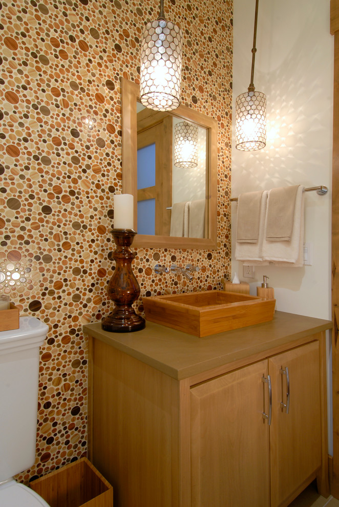 Photo of a contemporary powder room in Denver with a vessel sink, raised-panel cabinets, medium wood cabinets and a two-piece toilet.
