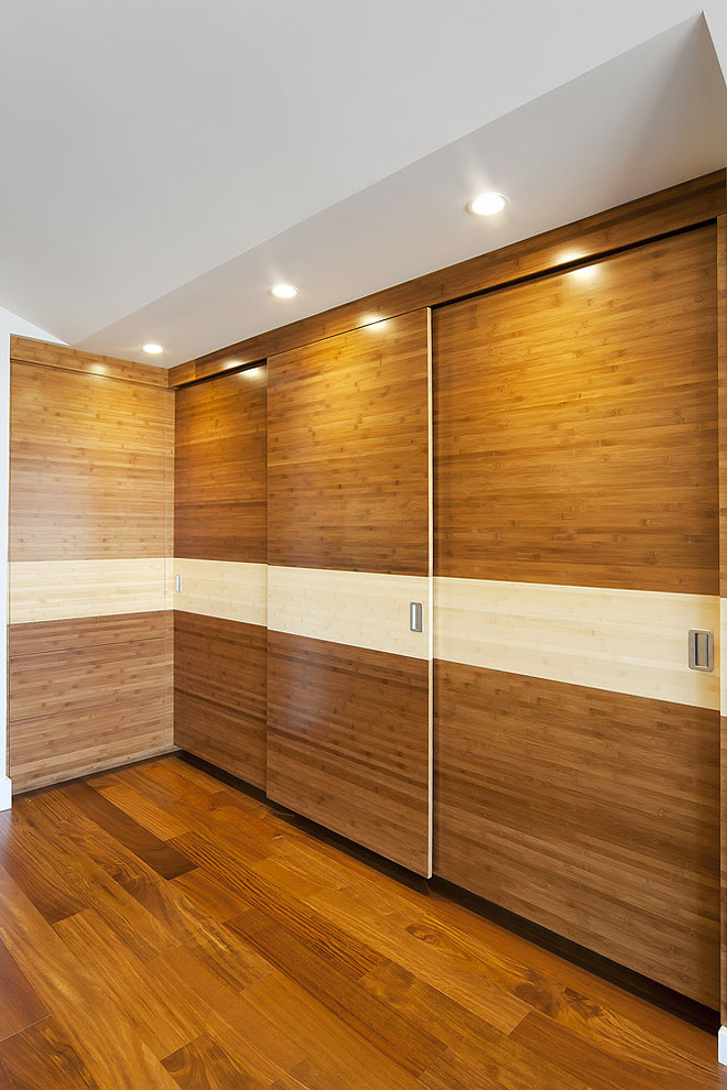 Inspiration for a large contemporary gender-neutral dressing room in San Francisco with flat-panel cabinets, medium wood cabinets and medium hardwood floors.