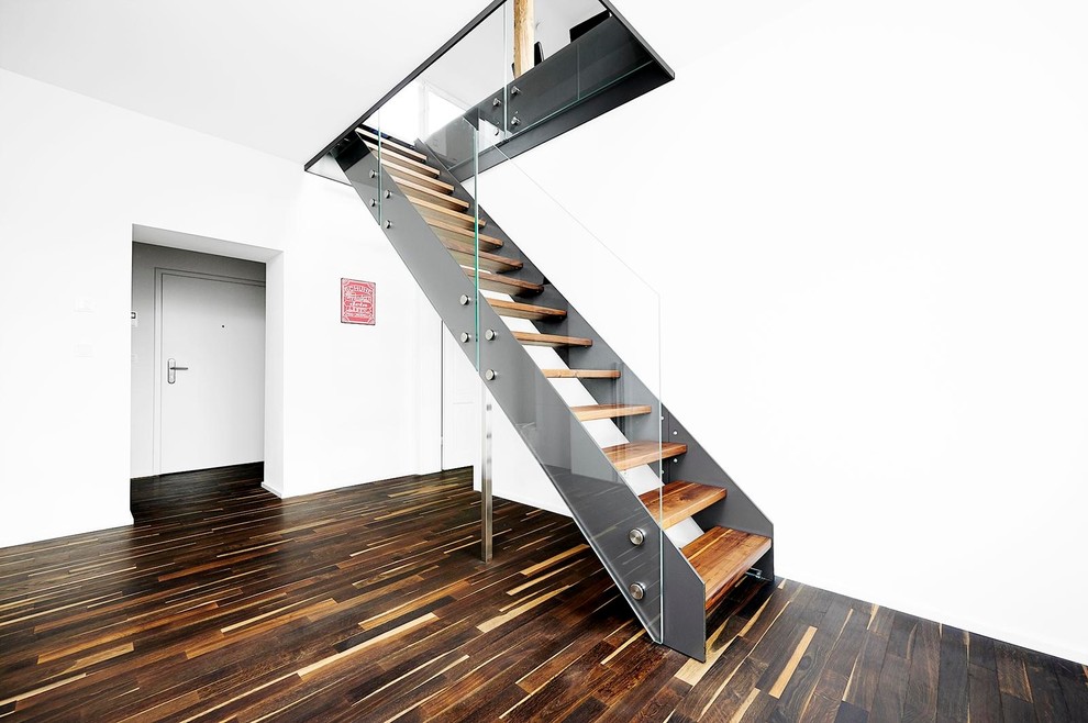 Photo of a mid-sized contemporary wood straight staircase in Essen with open risers.